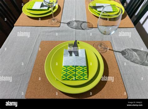 Vibrant green-themed table setting with origami-folded napkins in a ...
