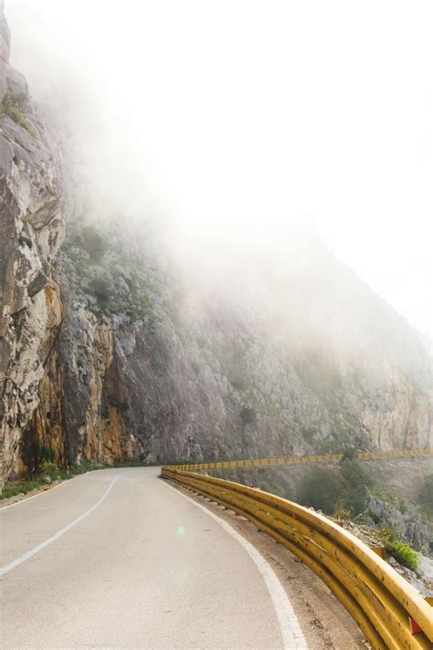 Photography of Road Near Foggy Mountain · Free Stock Photo