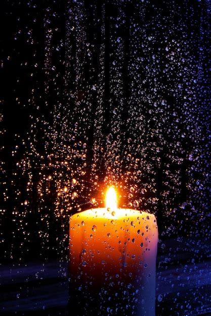 Premium Photo | A candle in the rain with water drops on it