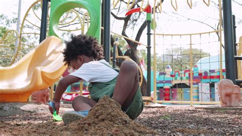 African American child having fun playing with sand in playground 20461790 Stock Video at Vecteezy