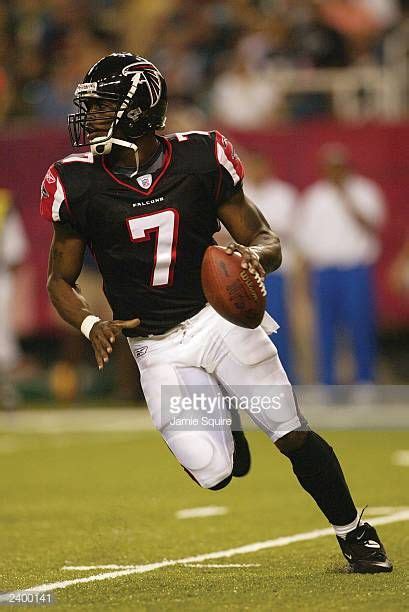 Quarterback Michael Vick of the Atlanta Falcons rolls out against the ...