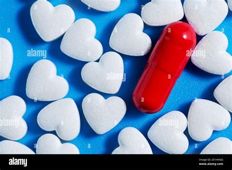 heart-shaped tablets and red pill. on blue background. medicine, cardiology health Stock Photo ...