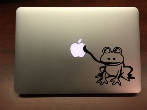 an apple laptop with a frog sticker on it