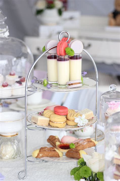 three tiered trays filled with pastries and desserts on top of a table