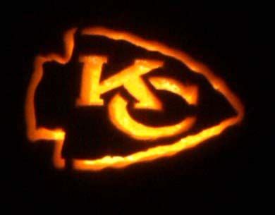 an orange and black photo of the kansas chiefs logo on a pumpkin that has been carved into it