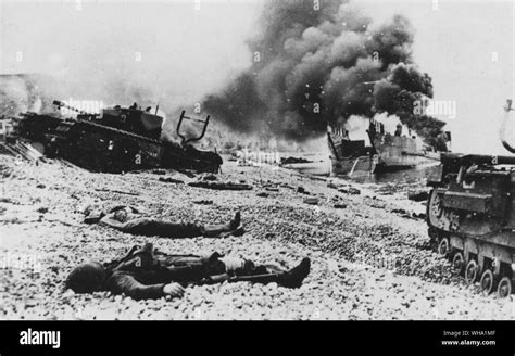 WW2: After the raid on Dieppe, tanks and landing craft on the beach with the bodies of dead ...