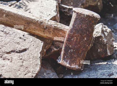 Rusty sledgehammer on broken bricks and concrete stones. Metal ...