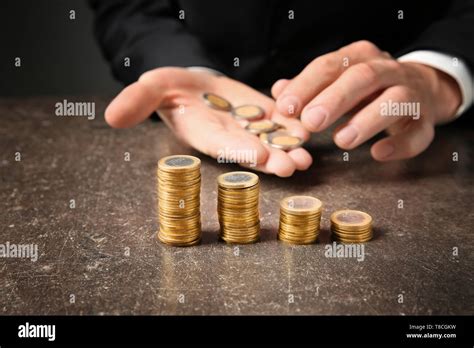 Man counting coins at table. Savings concept Stock Photo - Alamy