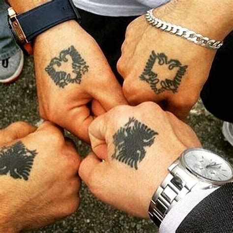 three people holding hands with tattoos on them