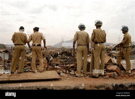 Police constables keep watch to prevent any untoward incidents demolition illegal slums Mankhurd ...