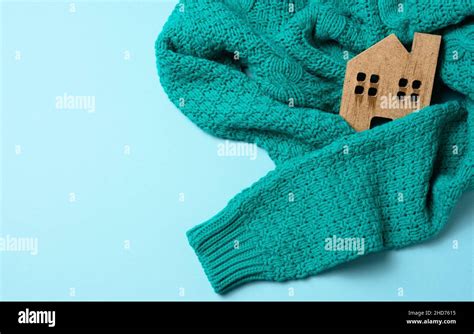 brown wooden model of the house is wrapped in a warm knitted sweater. Loan concept for house ...