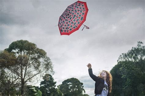 Image of Young girl losing her umbrella on a windy winter day - Austockphoto