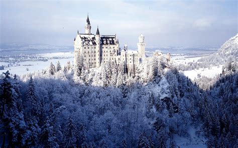 a castle is surrounded by snow covered trees