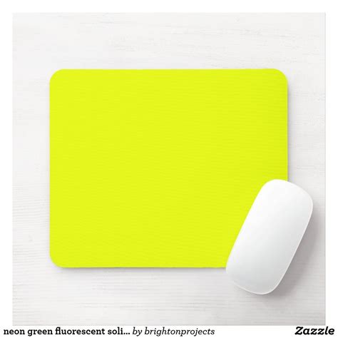 a yellow mouse pad next to a computer mouse on a white surface with the words neon green ...