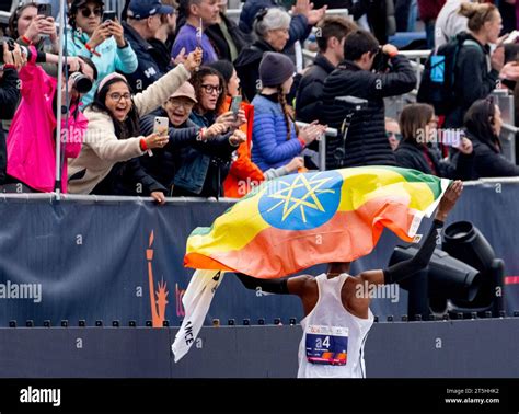 Tamirat Tola, of Ethiopia, runs past spectators with his home country's ...