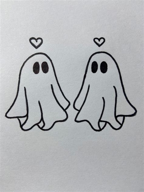 two ghost faces with hearts on their foreheads, drawn in black and ...