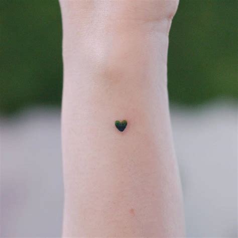 Minimalist heart tattoo on the wrist.