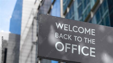 Welcome back to the office on a city-center sign in front of a modern office building Stock ...