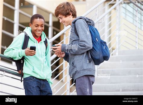 Two High School Students Outside Building With Mobiles Stock Photo - Alamy