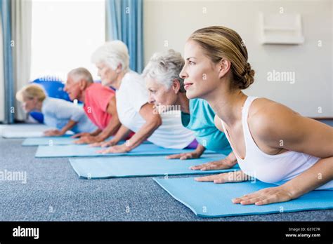 Instructor performing yoga with seniors Stock Photo - Alamy