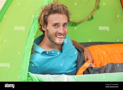 Young man in sleeping bag inside of tent Stock Photo - Alamy