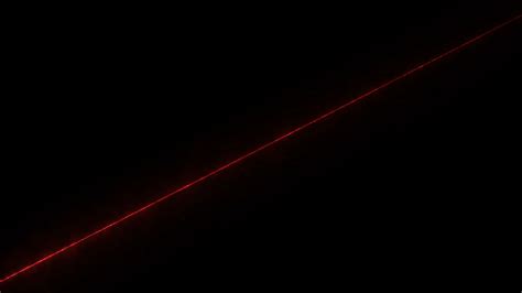 A red laser beam shines diagonally on a black background 15231359 Stock Video at Vecteezy