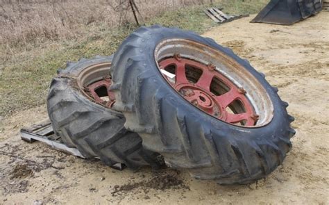 PAIR OF 15.5-38 REAR TRACTOR TIRES ON FARMALL RIMS | Live and Online Auctions on HiBid.com