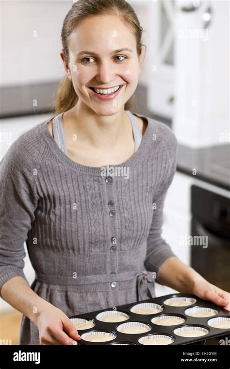 A woman making muffins in white kitchen Stock Photo - Alamy