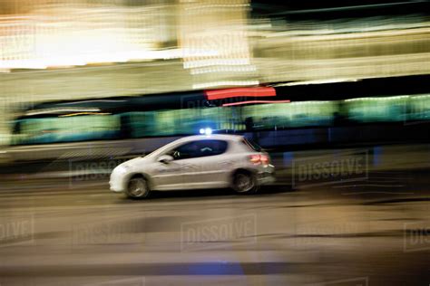 Car speeding down street at night - Stock Photo - Dissolve