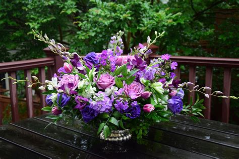 A large table centerpiece with gladiolas, dendrobium orchids, roses, stock, alstroemerias, li ...