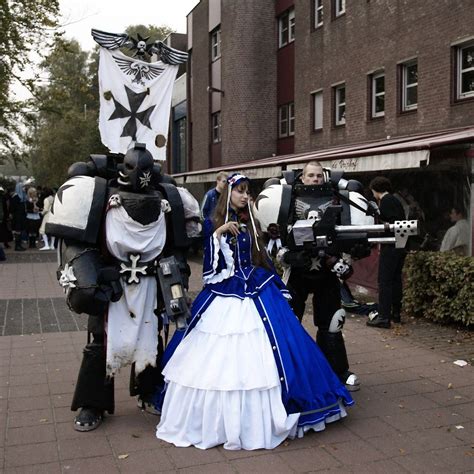 two cosplays dressed in costumes are walking down the street while people look on