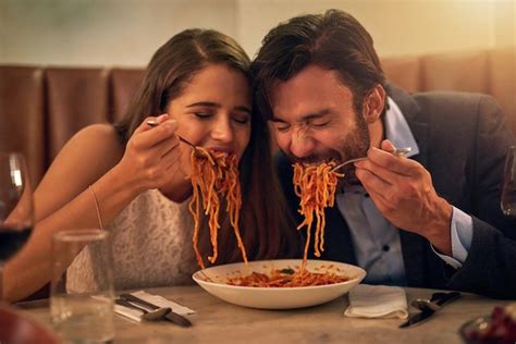 Premium Photo | Love is all consuming shot of a young couple sharing a plate of spaghetti during ...