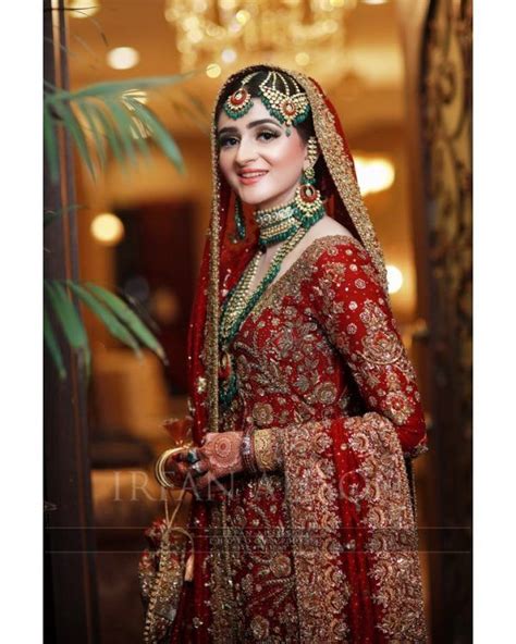 a woman in a red and gold bridal outfit