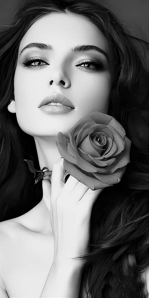 a black and white photo of a woman with long hair holding a rose in her hand