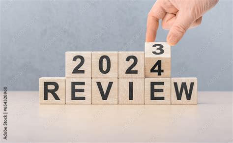 Review 2024. hand flips wooden cube and changes words REVIEW 2023 to REVIEW 2024. New year 2024 ...