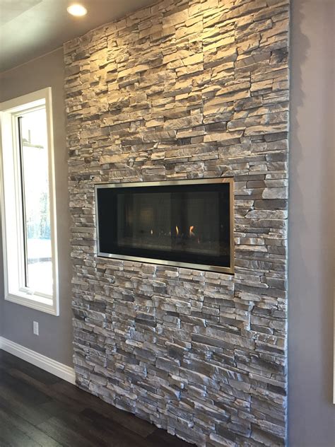 Contemporary linear fireplace with silver lining stacked stone. No mantel for this modern look ...