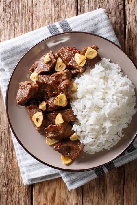 spicy beef salpicao with garlic and rice closeup on a table. Vertical ...