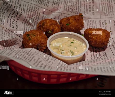 Hush puppies from balls of cornmeal deep fried and served in a tray with creamy dipping Stock ...