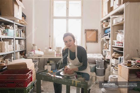 Caucasian woman is shaping pottery clay on a pottery wheel in a ceramic workshop. — skillful ...