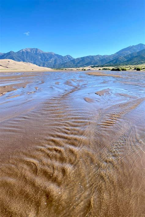 Sandboarding in Colorado (Great Sand Dunes) - Champagne Tastes®