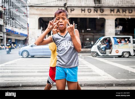 Poor Filipino street children play at a busy junction in the China Town, Binondo District of ...