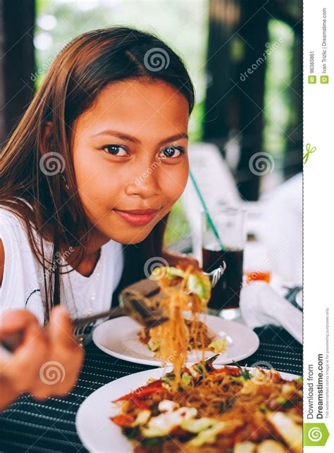 Young Asian Woman At The Restaurant Eating Stir Fry Rice Noodle With Meat And Vegetables ...