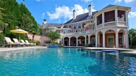 a large house with a pool in front of it and an umbrella on the side