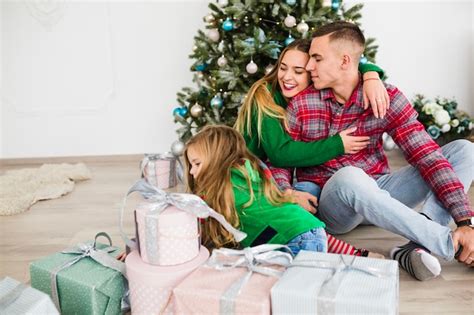 Free Photo | Happy family sitting in front of christmas tree