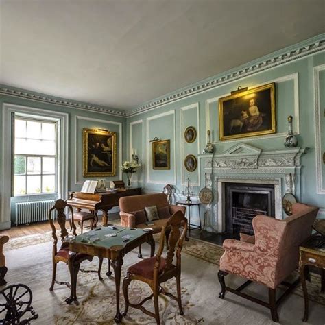 a living room filled with furniture next to a fire place and paintings ...