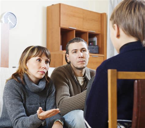 Parents talking to teenager in living room. - Unhappy Marriage