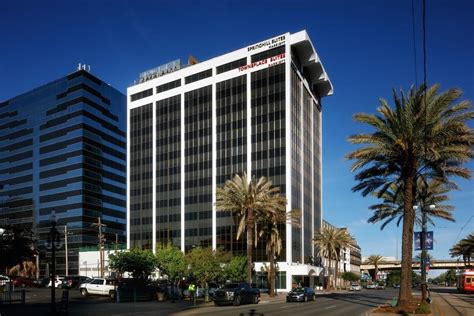 a very tall building sitting on the side of a road next to some palm trees