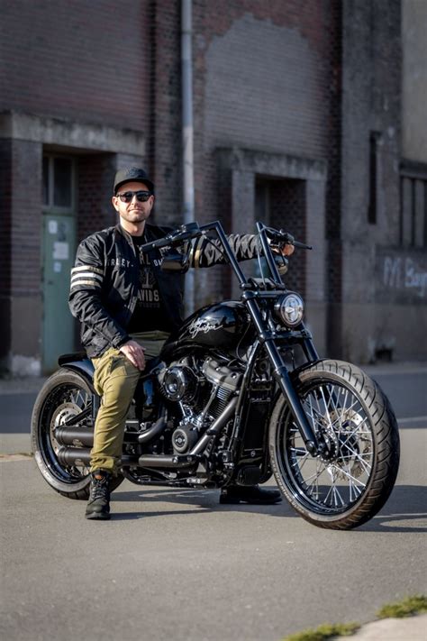 a man sitting on top of a black motorcycle