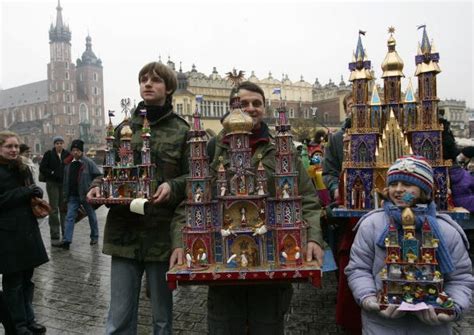 three people standing in front of an elaborately decorated clock tower on a rainy day