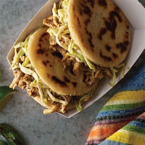 two pita breads sitting on top of a white plate next to a colorful towel